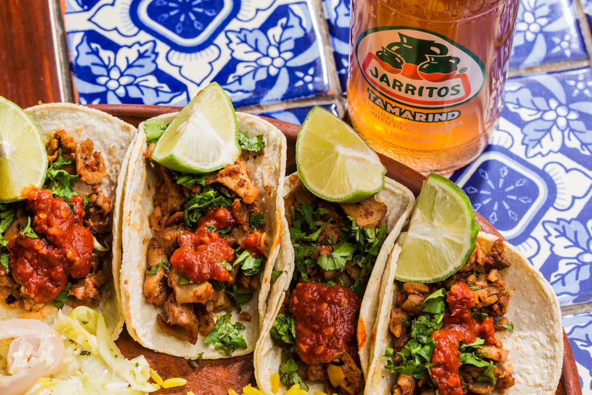 Close-up of freshly made street tacos with lime and salsa, served from a food truck